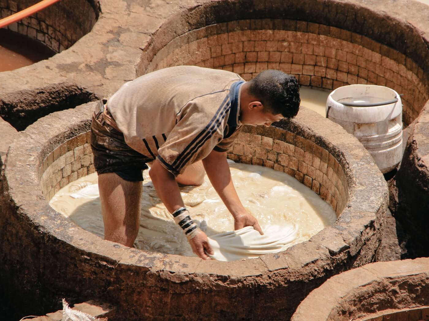 artizan in marrakech in vopsitoriile de piele unde sunt create pufuri si taburete marocane