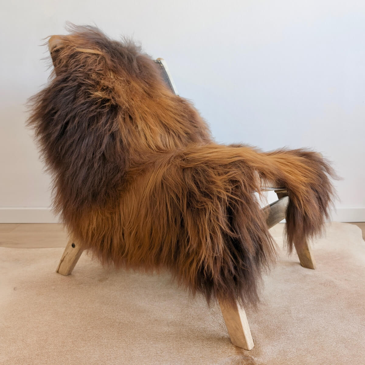 Covor din Blana Naturala de Oaie Islandeza cu fir extra lung de minim 10 cm, Maro Ruginiu 130 x 80 cm, pe scaun lounge