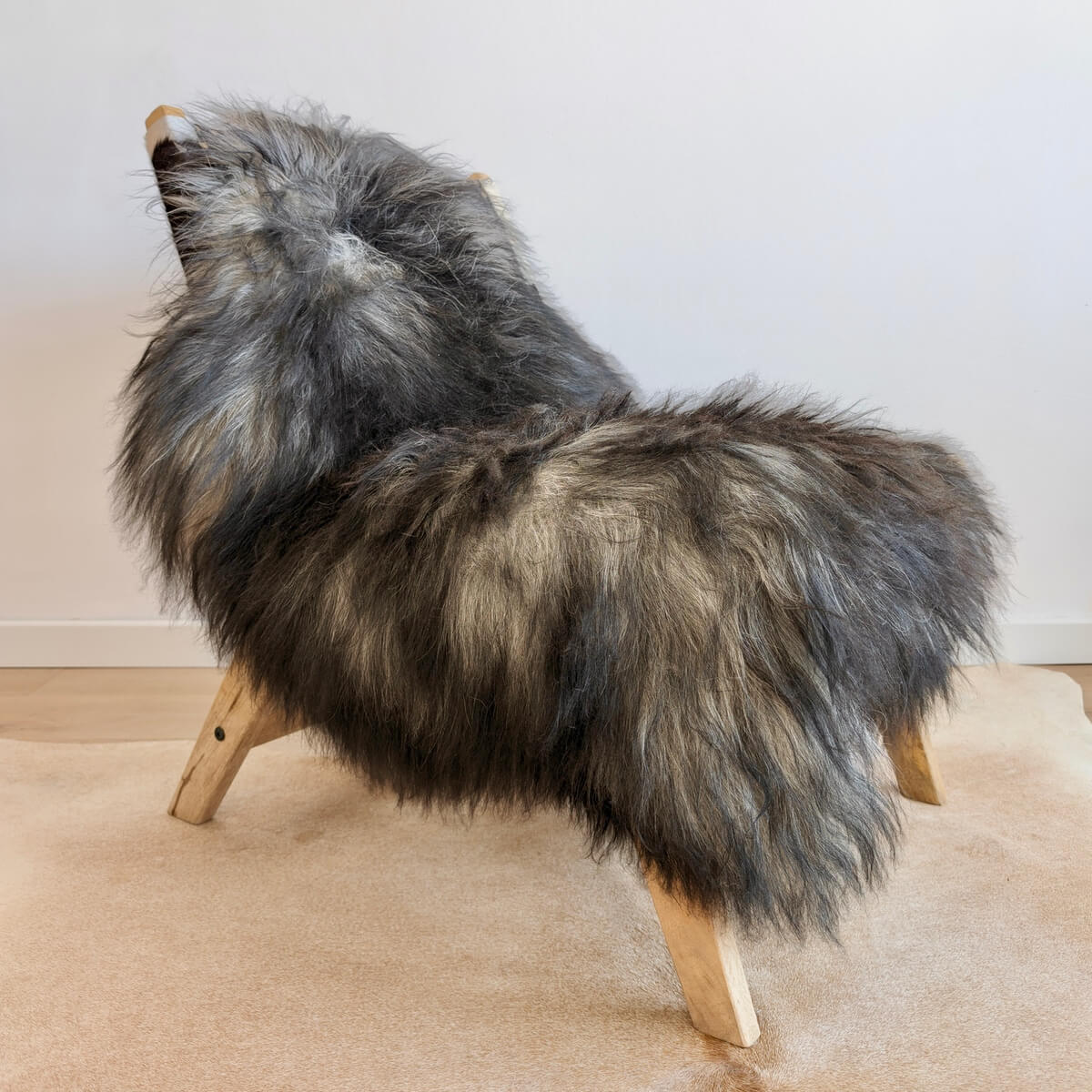 Covor din Blana Naturala de Oaie Islandeza cu fir extra lung de minim 10 cm, Nuante de Gri Inchis 130 x 80 cm, pe scaun lounge