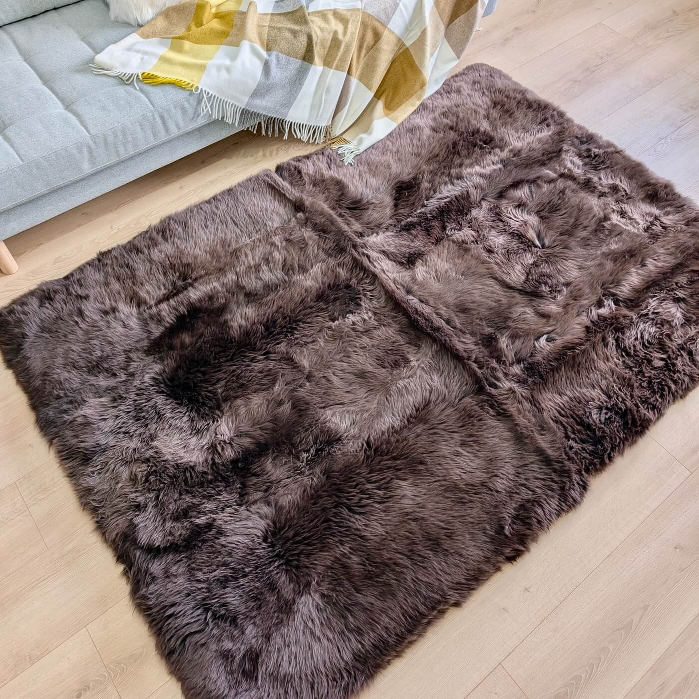 Covor Dreptunghiular din Blană Naturală de Oaie, Maro Ciocolatiu - mărime 180 x 120 cm - pe podea în living