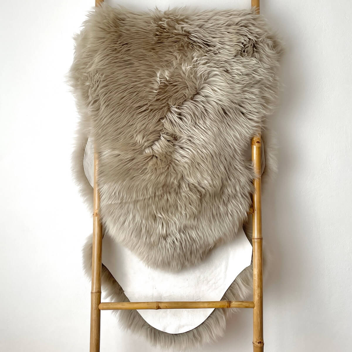 covor dublu din blana de oaie naturala, pufos si dens de culoare bej argintiu, pe scara