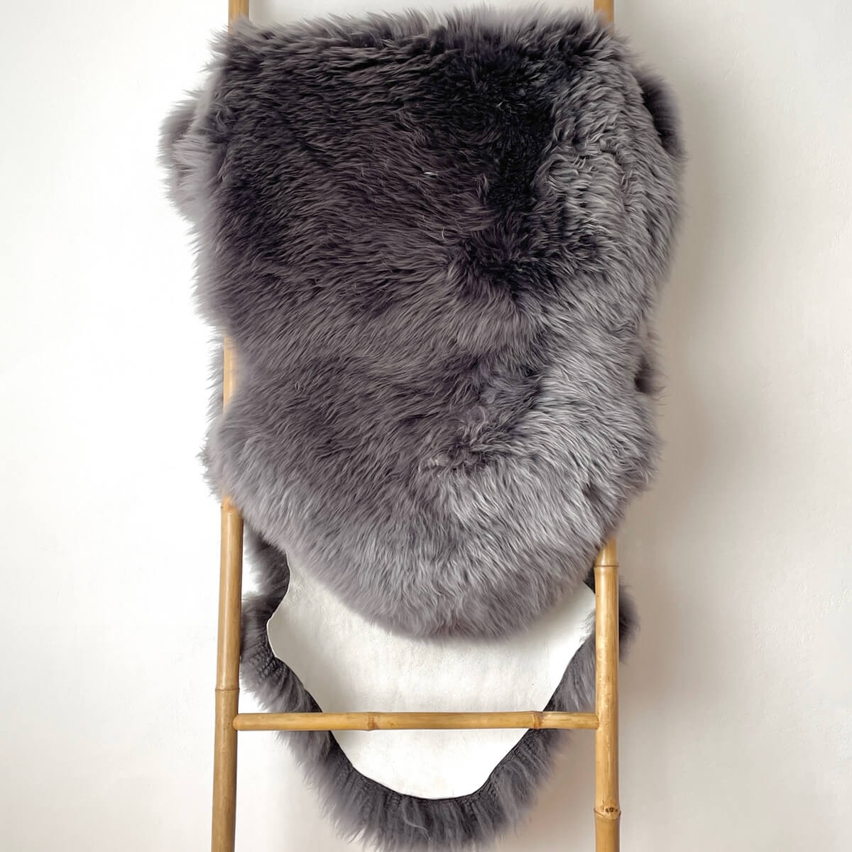 covor dublu din blana de oaie naturala, pufos si dens de culoare gri inchis, pe scara