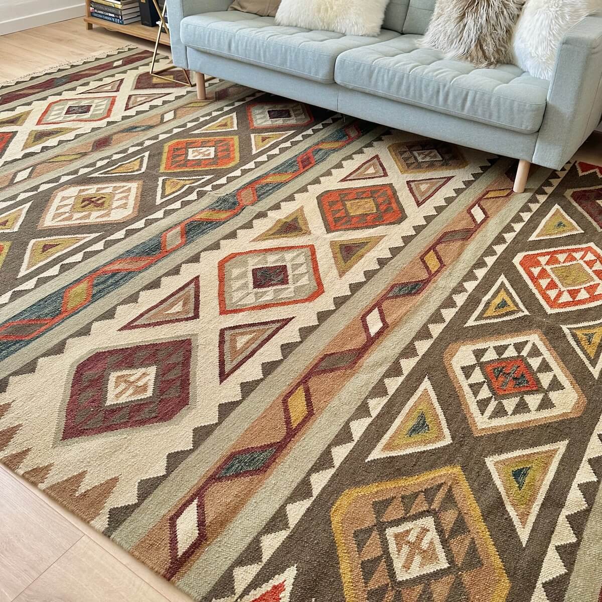 Covor traditional cu tesatura plata subtire Kilim Afshar, in mai multe culori calde de maro, teracotta si crem, intins pe podea
