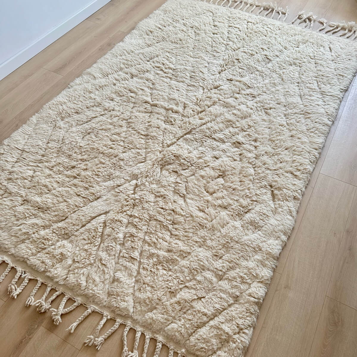 Covor marocan Berber din lana cu ciucuri - Beni Ourain (250cm x 160cm) - culoare alb crem cu model geometric de romburi - gros si pufos - pe podea