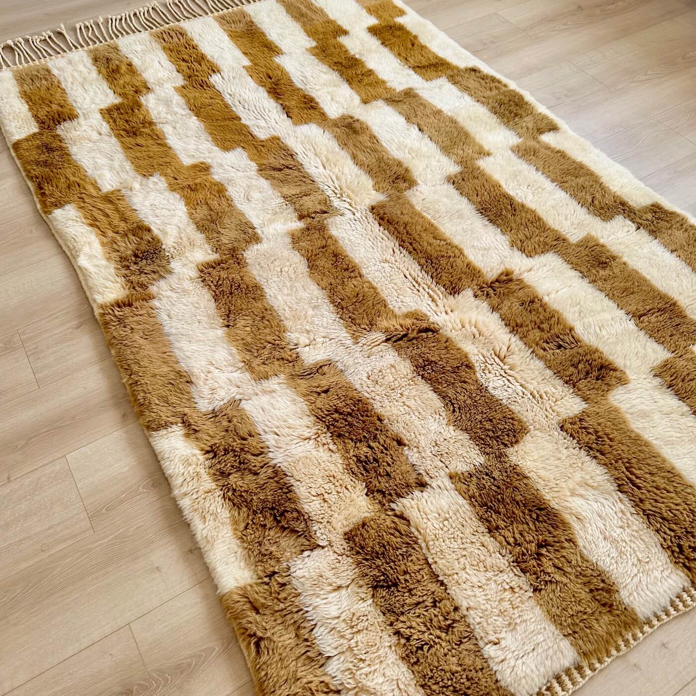 Covor gros și pufos din lână naturală realizat manual în Mrirt, Maroc. Dimensiune mare perfect pentru living sau dormitor- culoare bej maro - pe podea