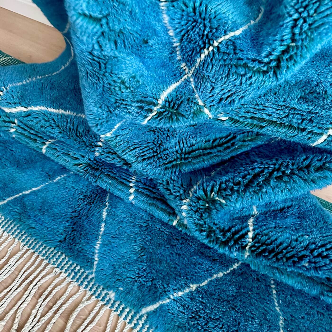 Covor gros și pufos din lână naturală realizat manual în Mrirt, Maroc. Perfect pentru living sau dormitor - dimensiune mare cu linii asimetrice albe pe un fundal albastru turcoaz - de aproape 2