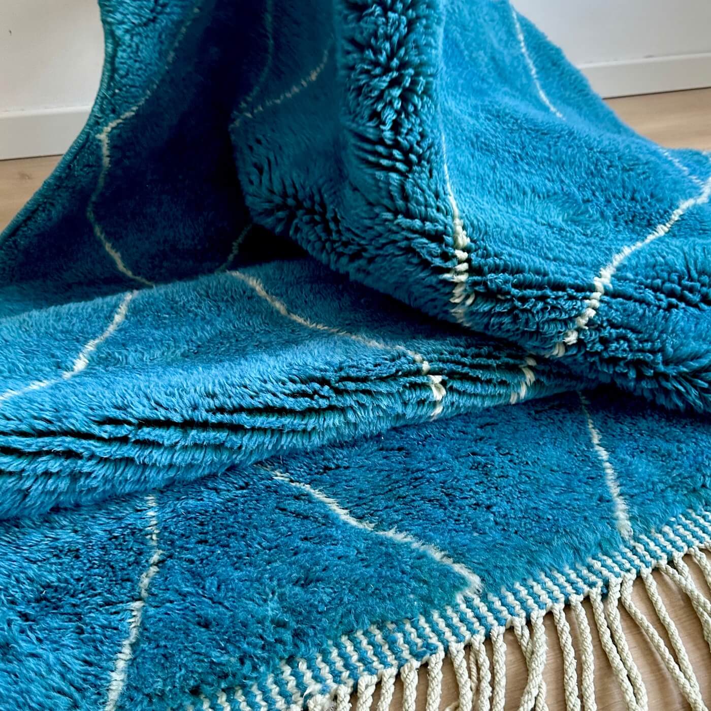 Covor gros și pufos din lână naturală realizat manual în Mrirt, Maroc. Perfect pentru living sau dormitor - dimensiune mare cu linii asimetrice albe pe un fundal albastru turcoaz - de aproape 1