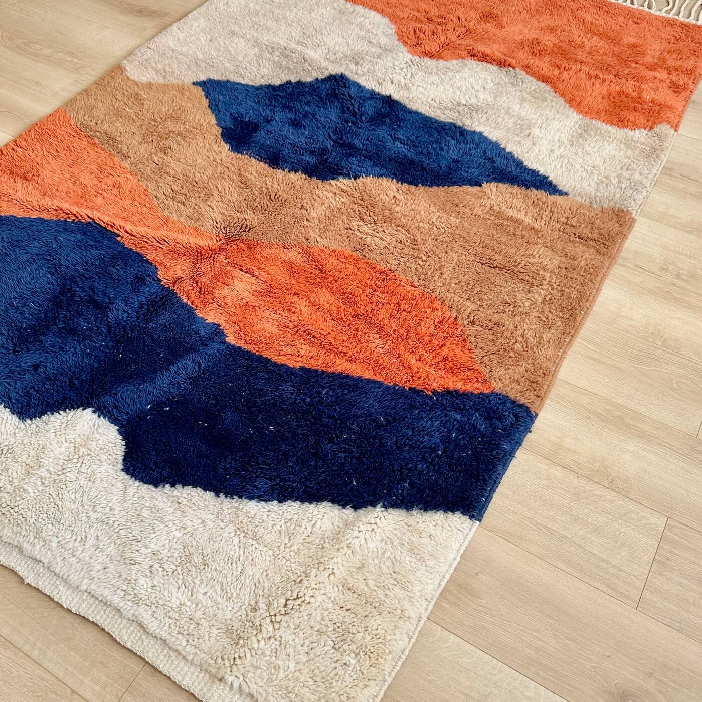 Covor modern gros și pufos din lână naturală realizat manual în Mrirt, Maroc. Perfect pentru living sau dormitor - dimensiune medie în culori de bej, maro, teracota si albastru - pe parchet 2