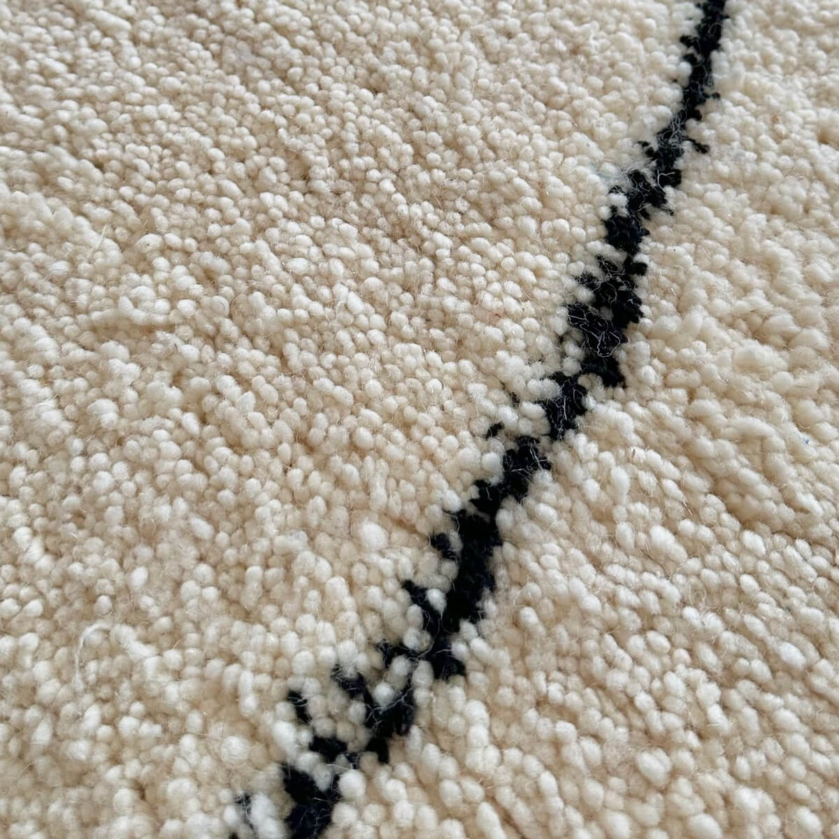 covor modern gros si pufos din lana creat manual in maroc, model alb cu dungi negre asimetrice, zoom