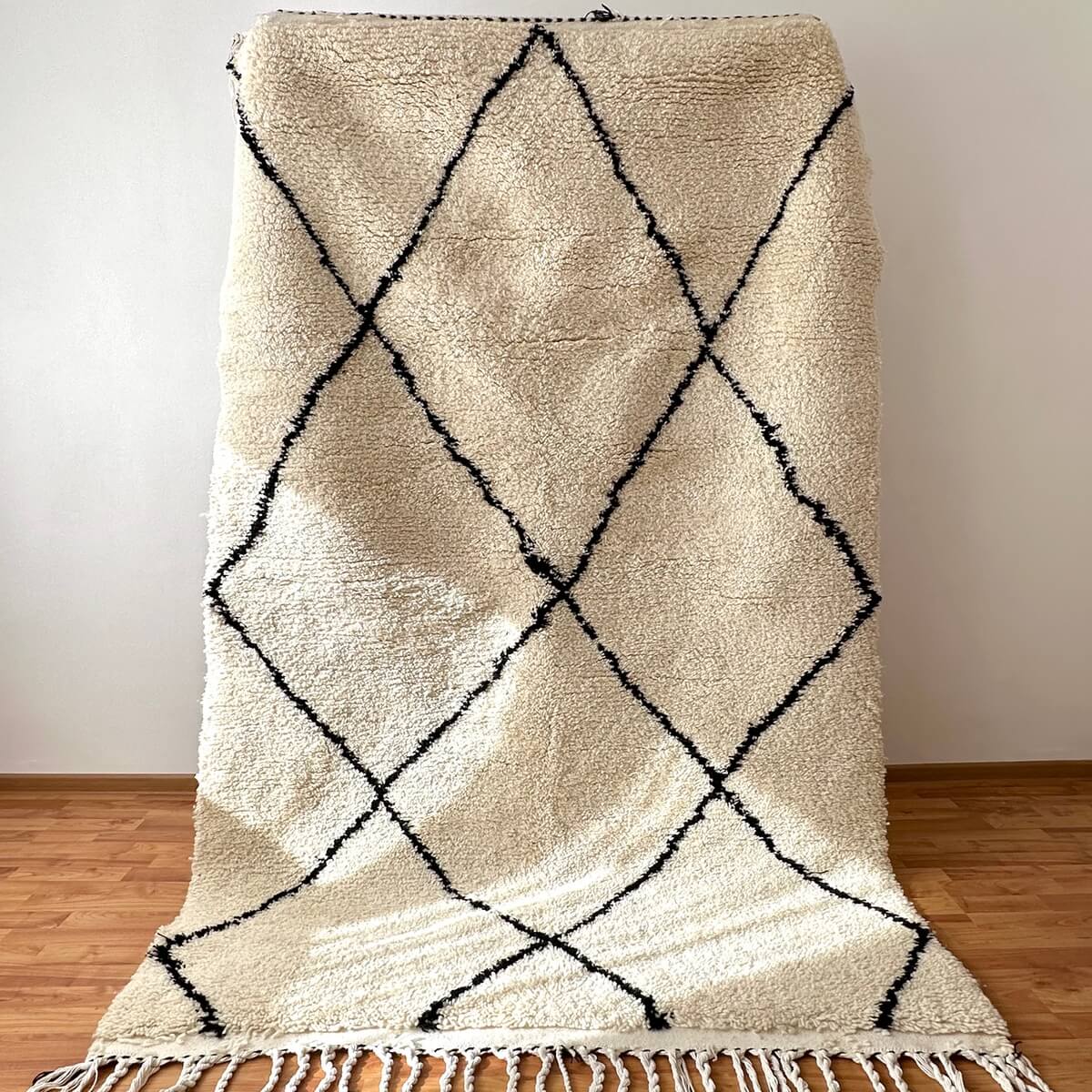 covor modern gros si pufos din lana creat manual in maroc, model alb cu dungi negre asimetrice