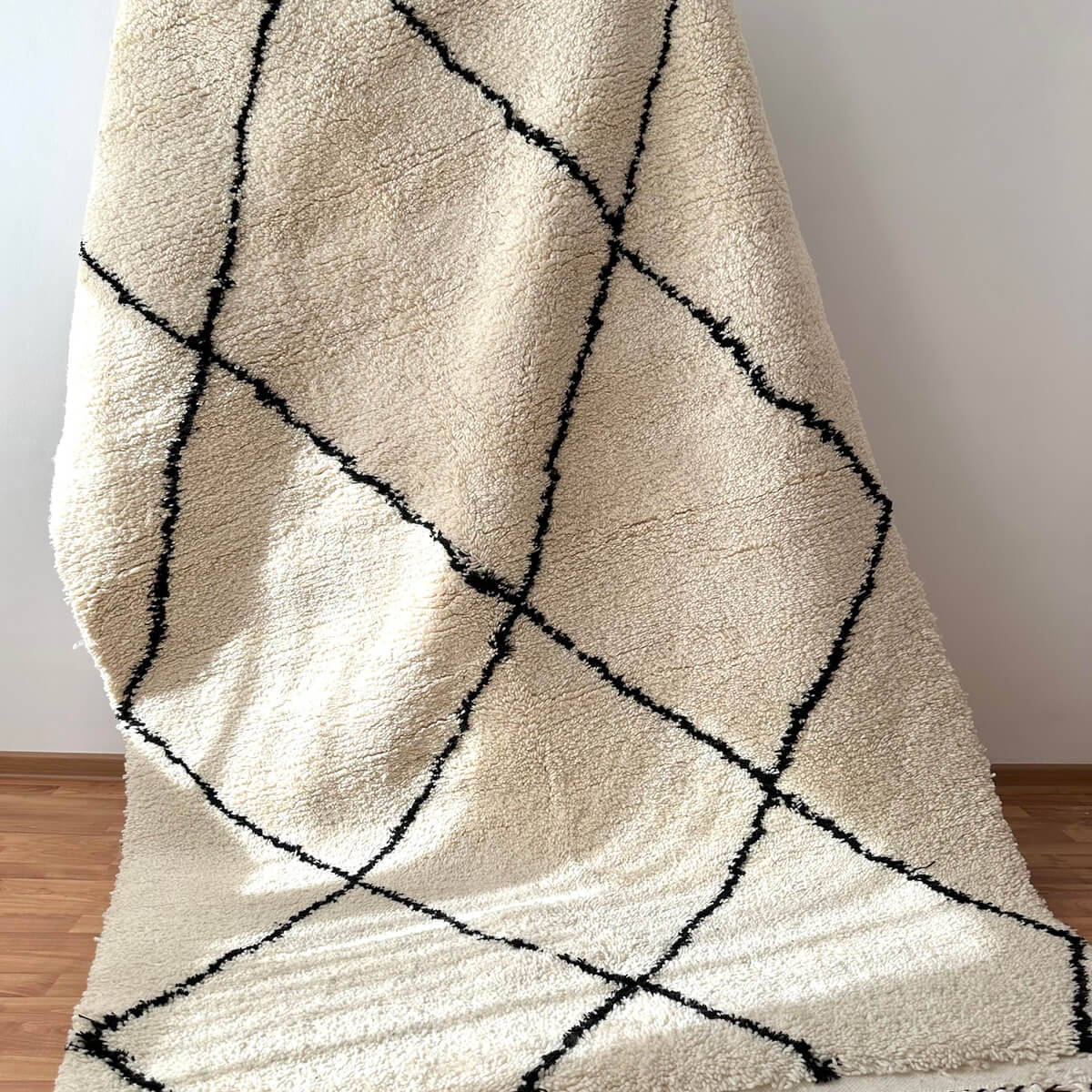 covor modern gros si pufos din lana creat manual in maroc, model alb cu dungi negre asimetrice