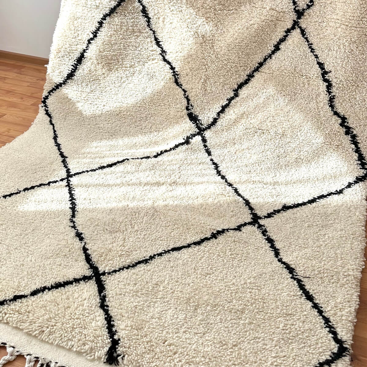 covor modern gros si pufos din lana creat manual in maroc, model alb cu dungi negre asimetrice