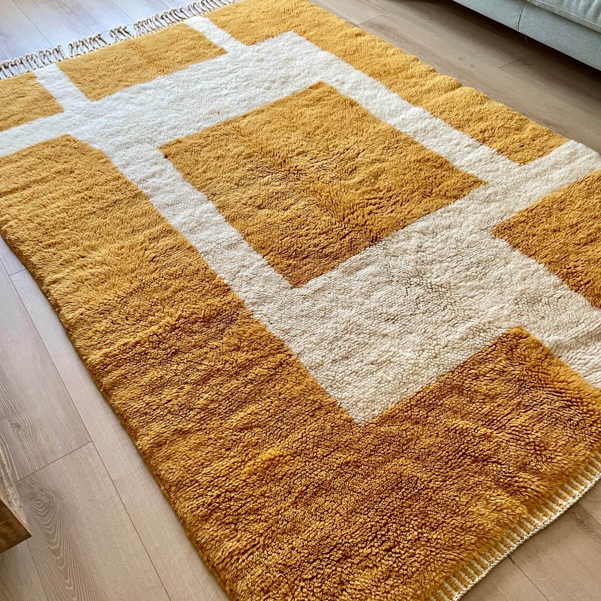 covor modern Berber Beni Mrirt creat manual din lana organica cu model contemporan in nuante naturale si galben turmeric, dens pufos si luxos, pe podea 4