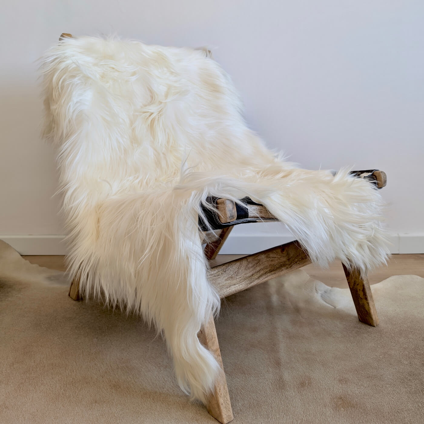 Covor din piele naturala de capra mongola cu fir extra lung si ondulat, nuanta alb ivory, pe fotoliu