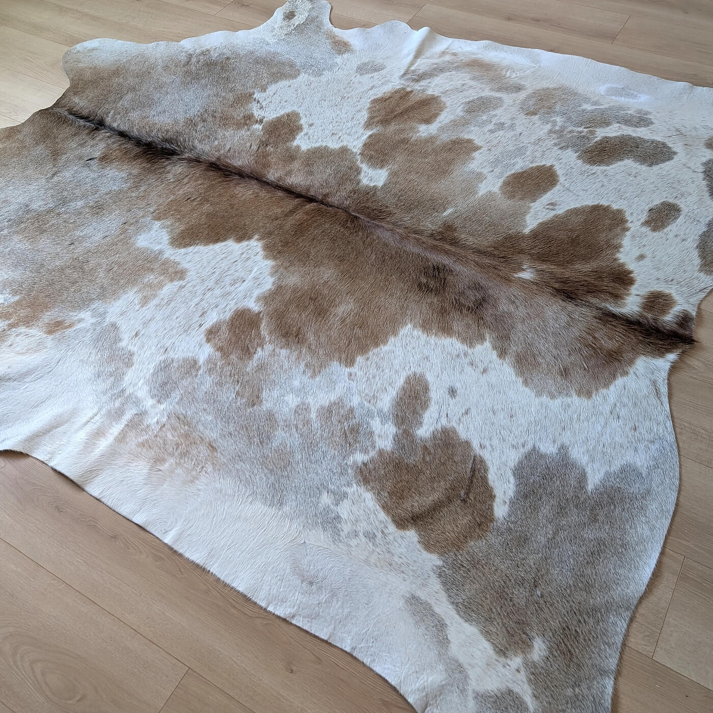 covor piele de vaca cu pete maro si alb mbch531 pe parchet