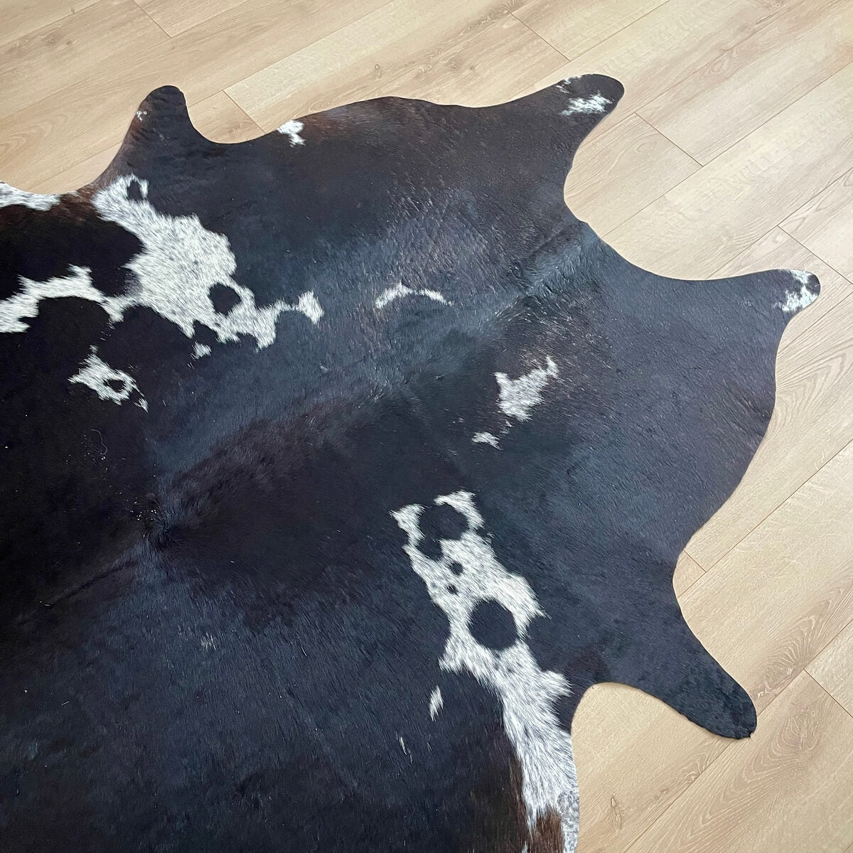 covor din piele de vaca neagra cu pete alb pestrit de forma asimetrica, mango+bloom