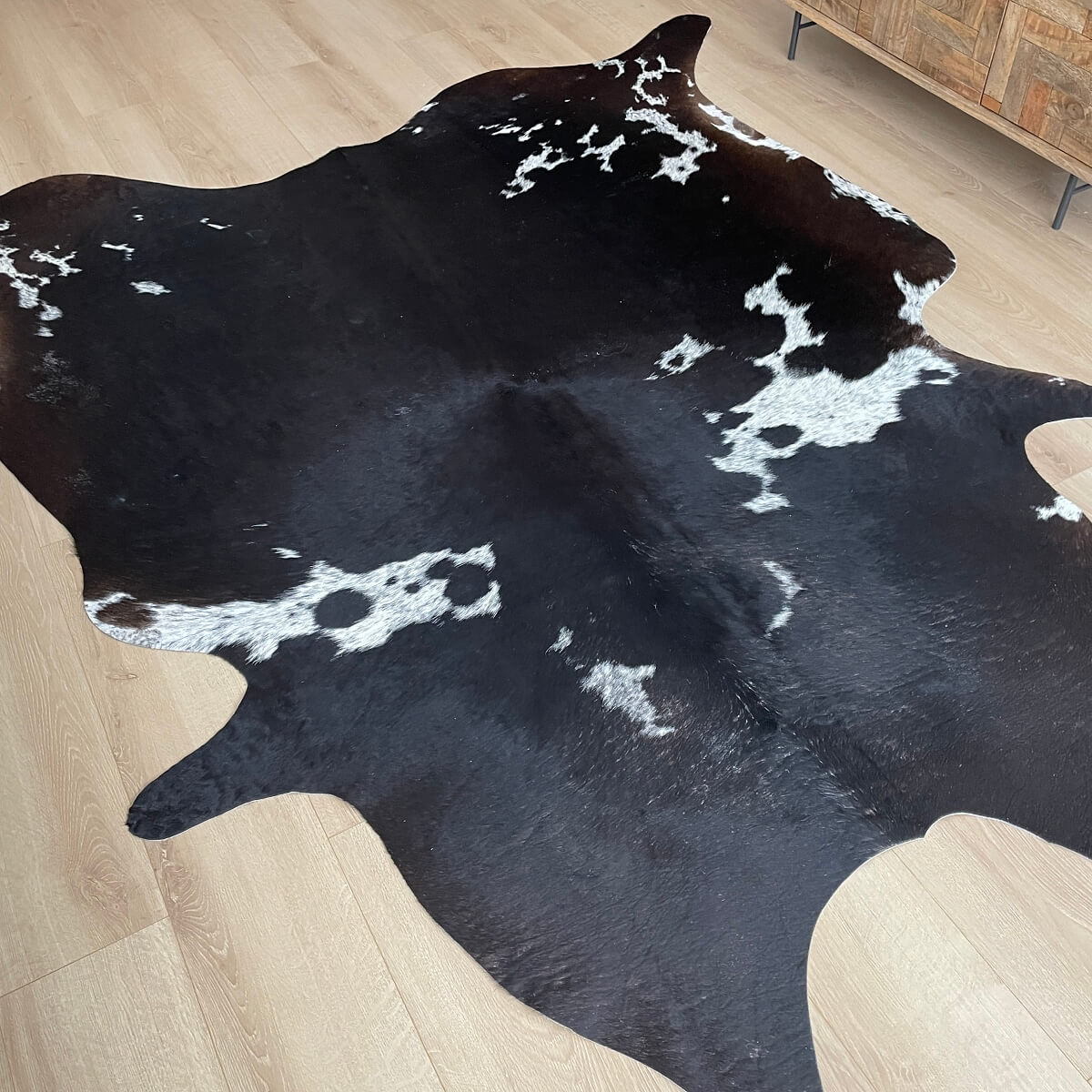 covor din piele de vaca neagra cu pete alb pestrit in living, mango+bloom