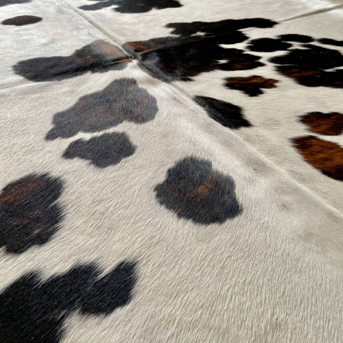 covor din piele naturala de vaca alb cu pete negru si maro detalii, mango+bloom