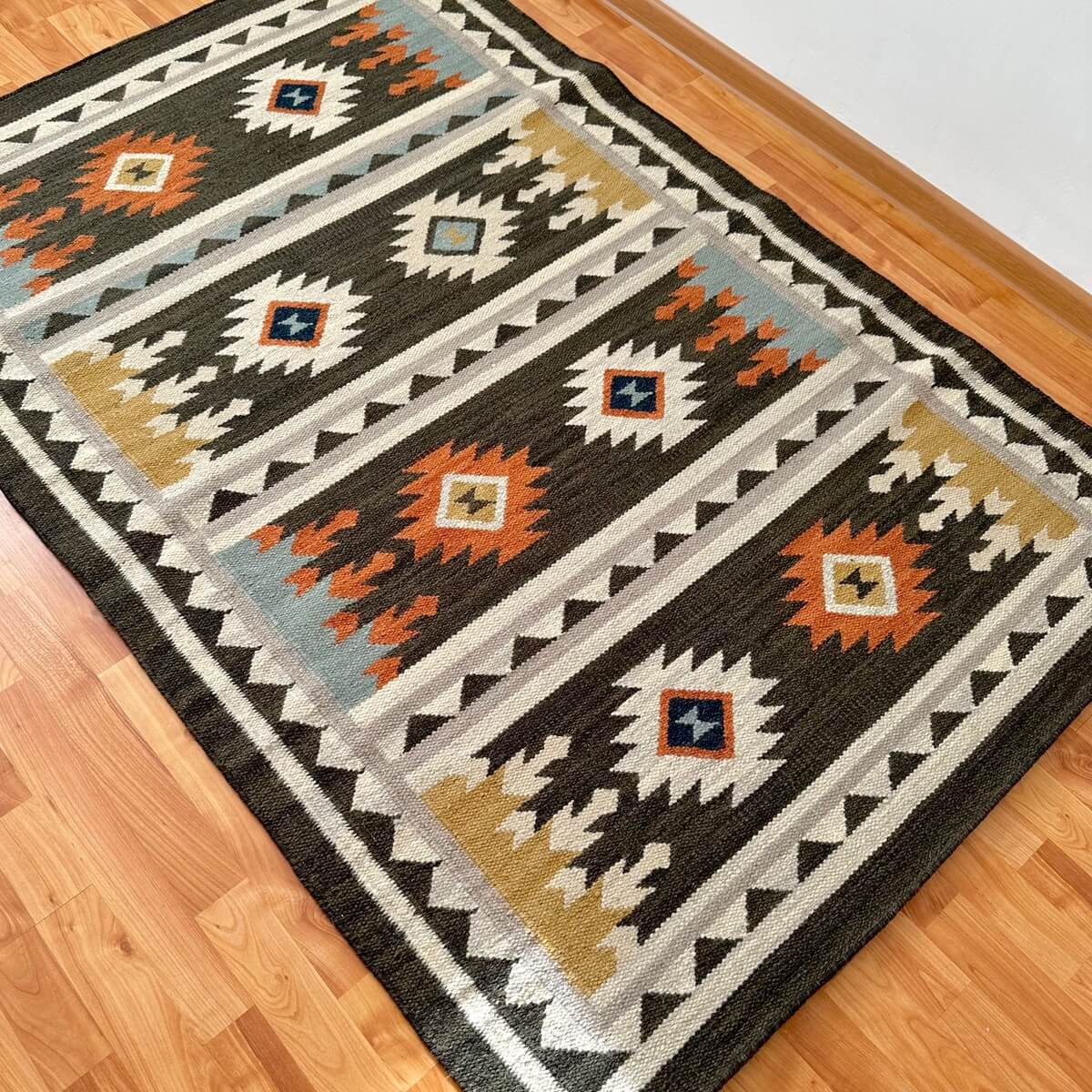 covor traditional kilim Sakala negru cu romburi tesut manual din lana, pe podea