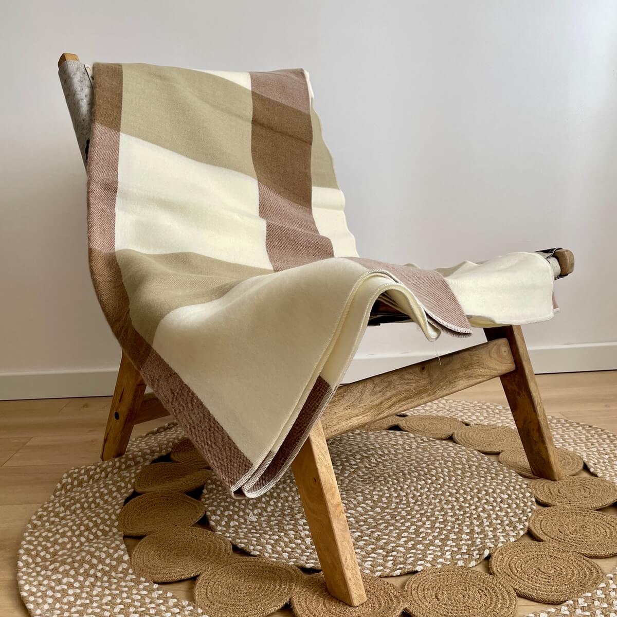 patura reversibila din lana de alpaca model in carouri, nunate de bej maro, pe scaun