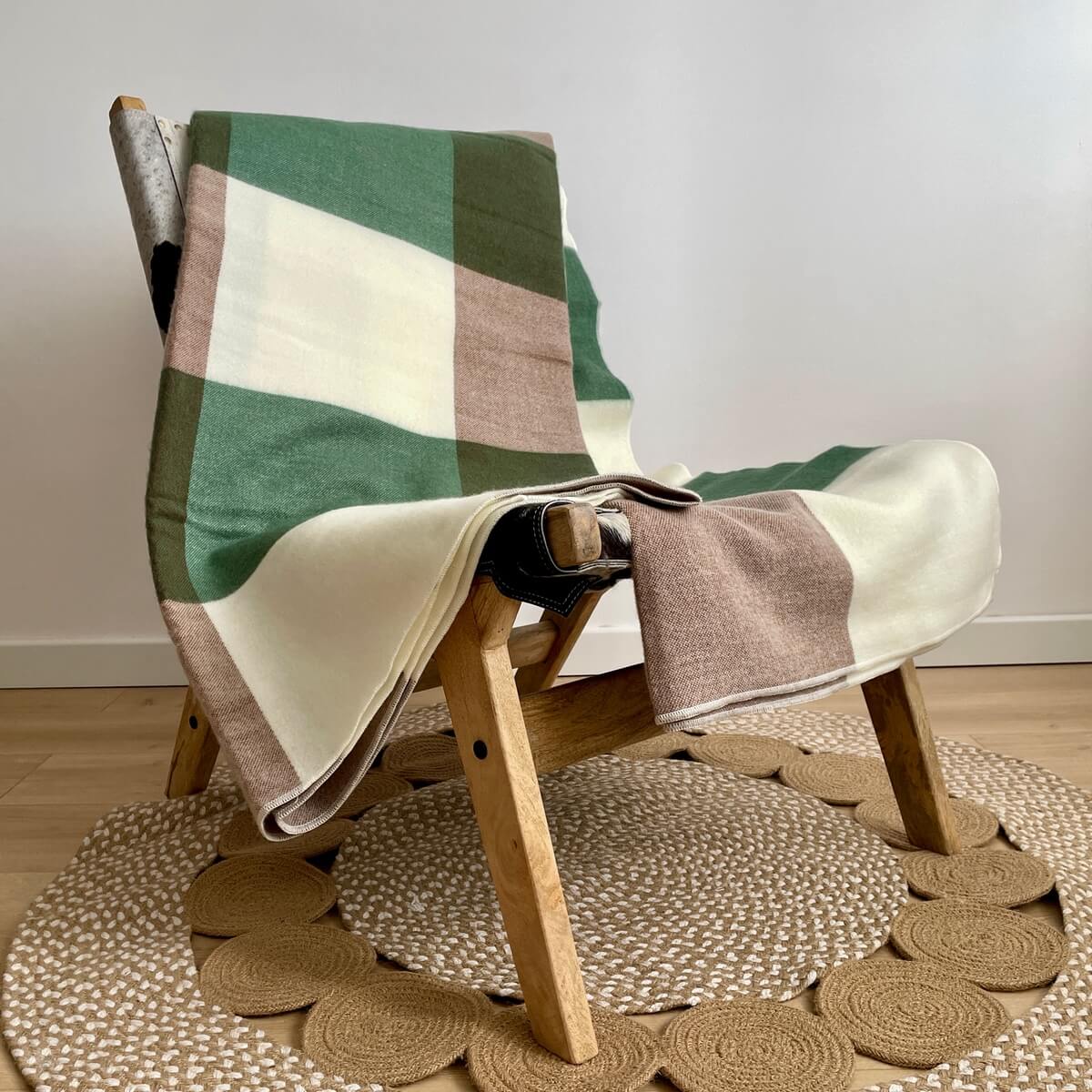 patura reversibila din lana de alpaca model in carouri, nunate de verde maro, pe scaun