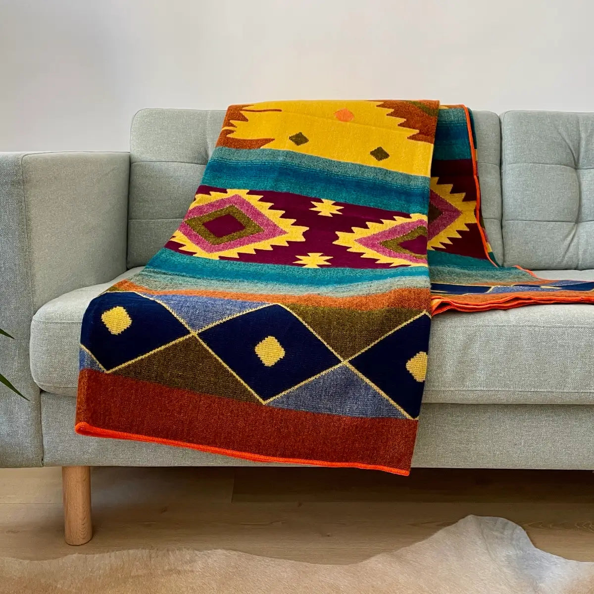 Patura reversibila din lana de alpaca Pichincha, Mustar, pe canapea