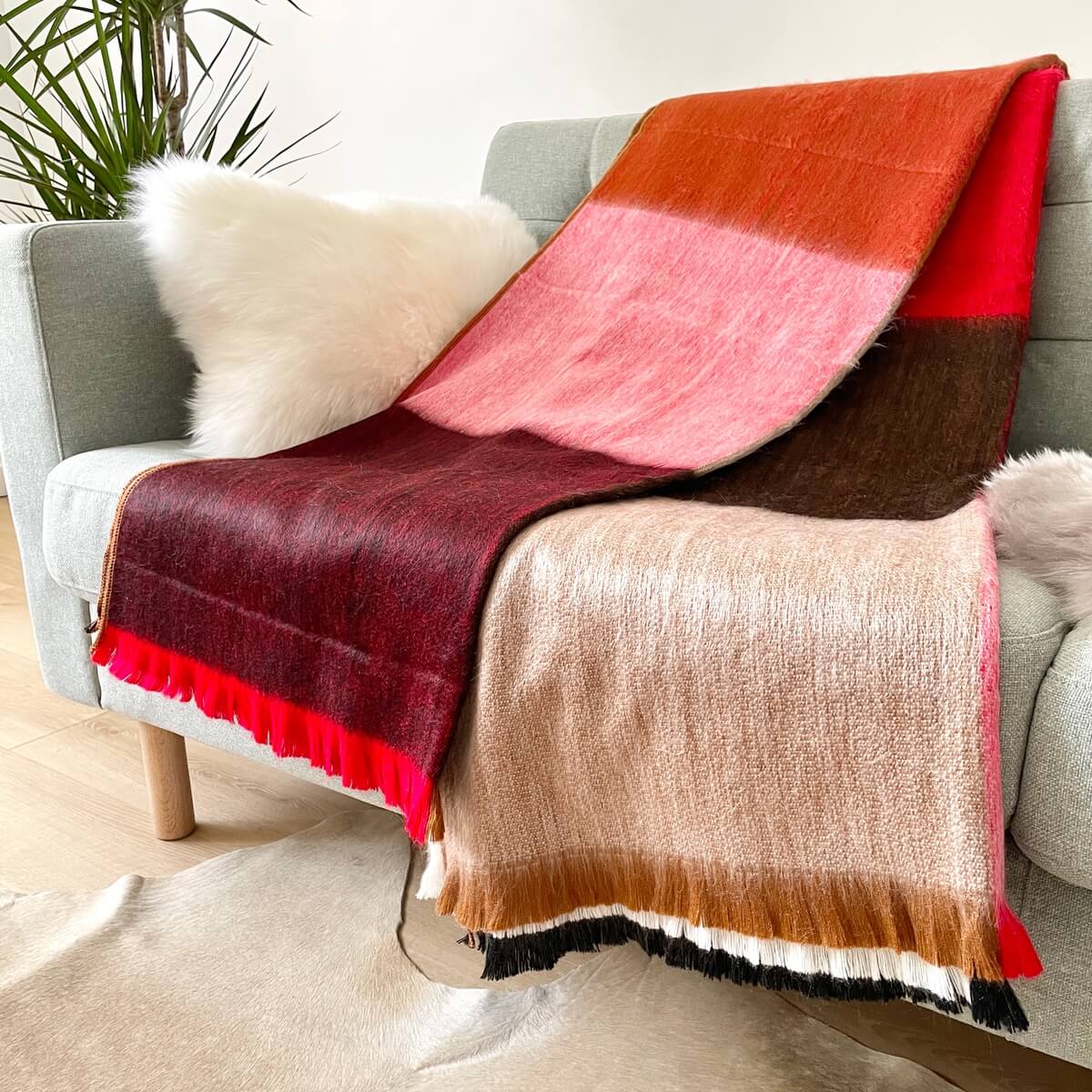 Patura in carouri din lana de alpaca, Rosu Multi, moale, pe canapea de aproape