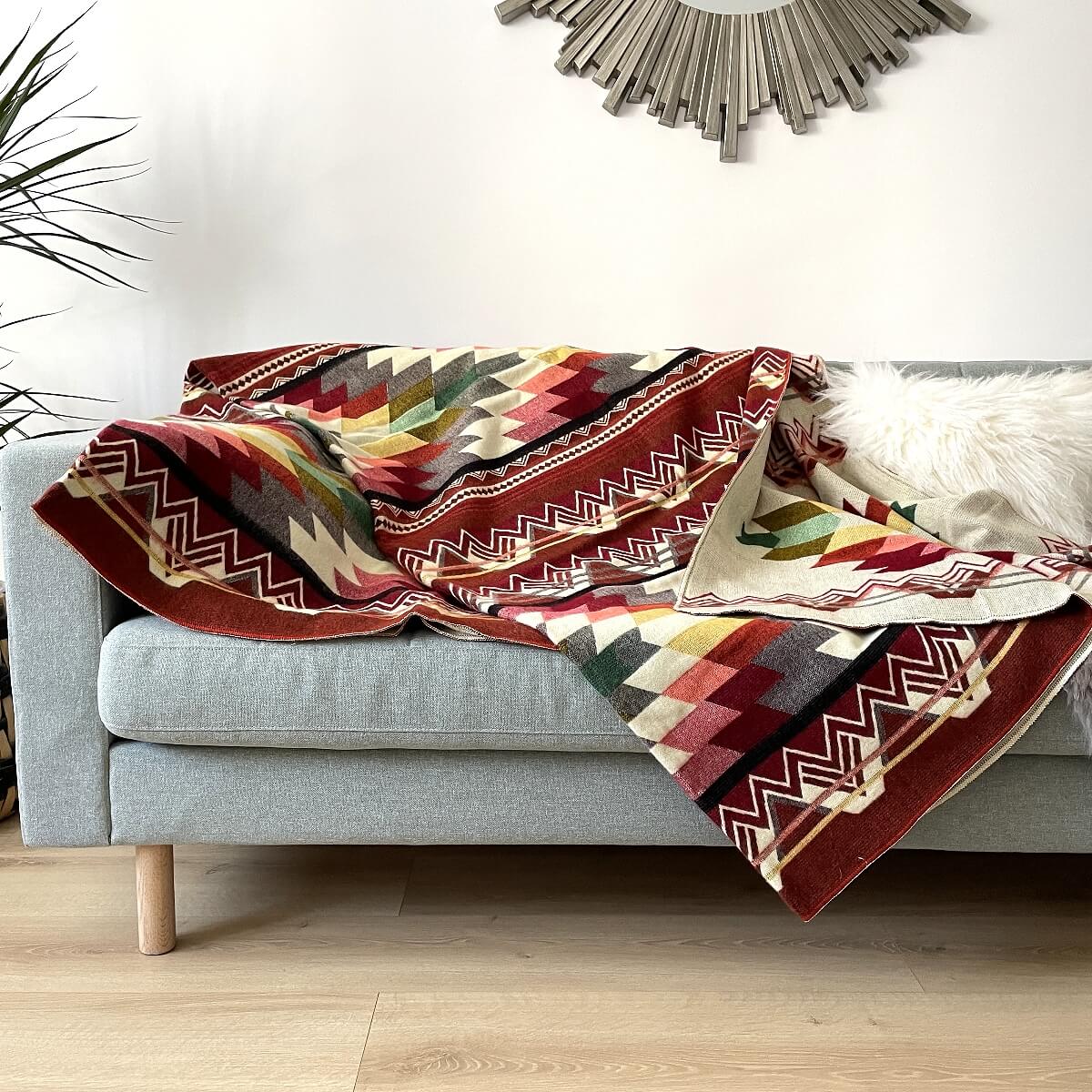 Patura reversibila din lana de alpaca antisana, portocaliu inchis pe canapea