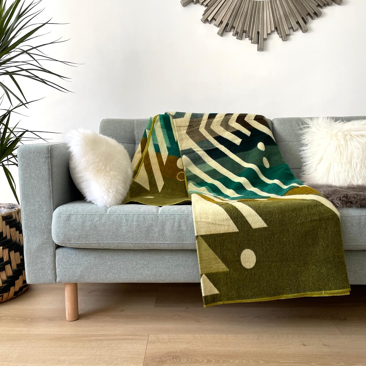 patura mare reversibila din lana de alpaca imbabura verde pe canapea