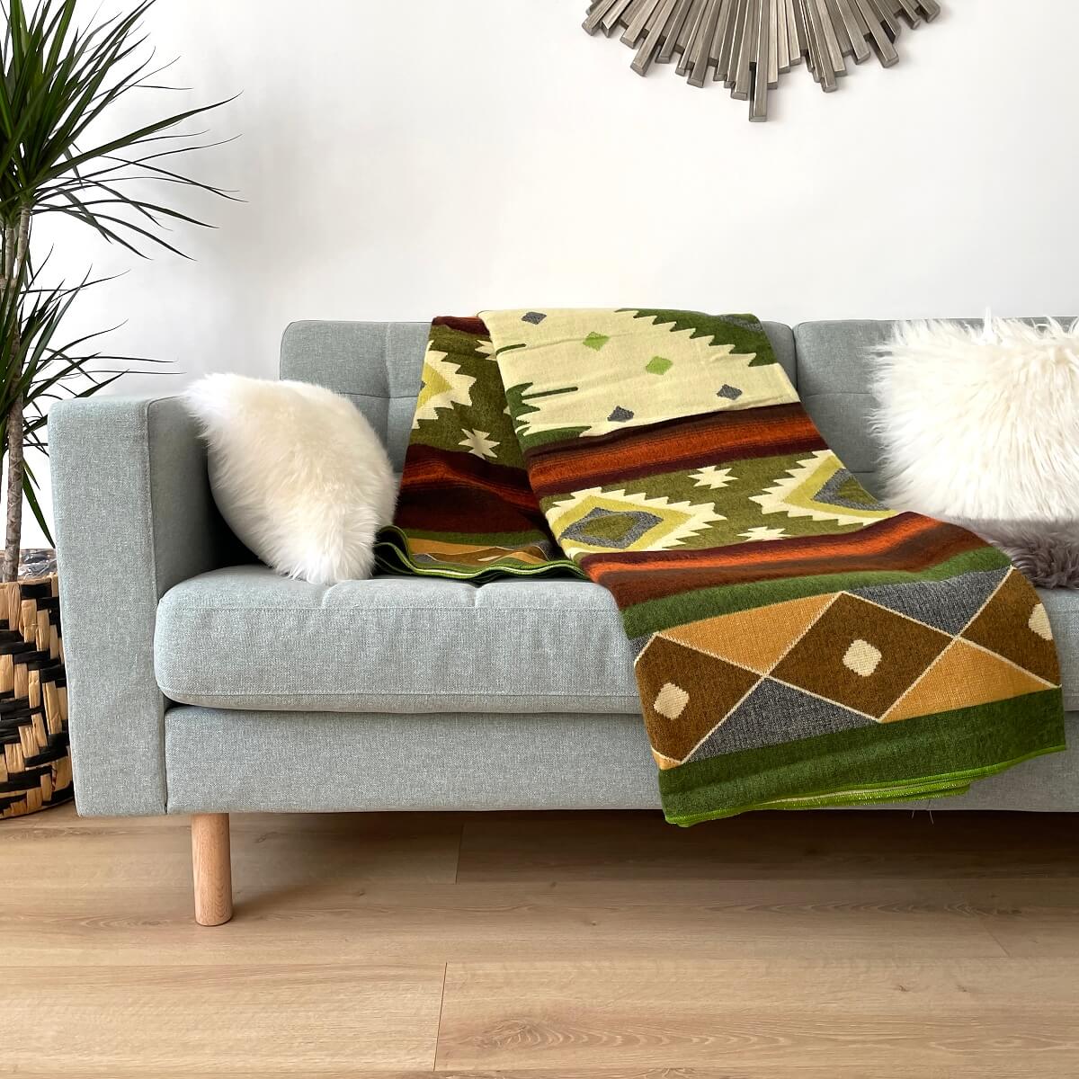 patura reversibila din lana alpaca quilotoa nuante de verde pe canapea,