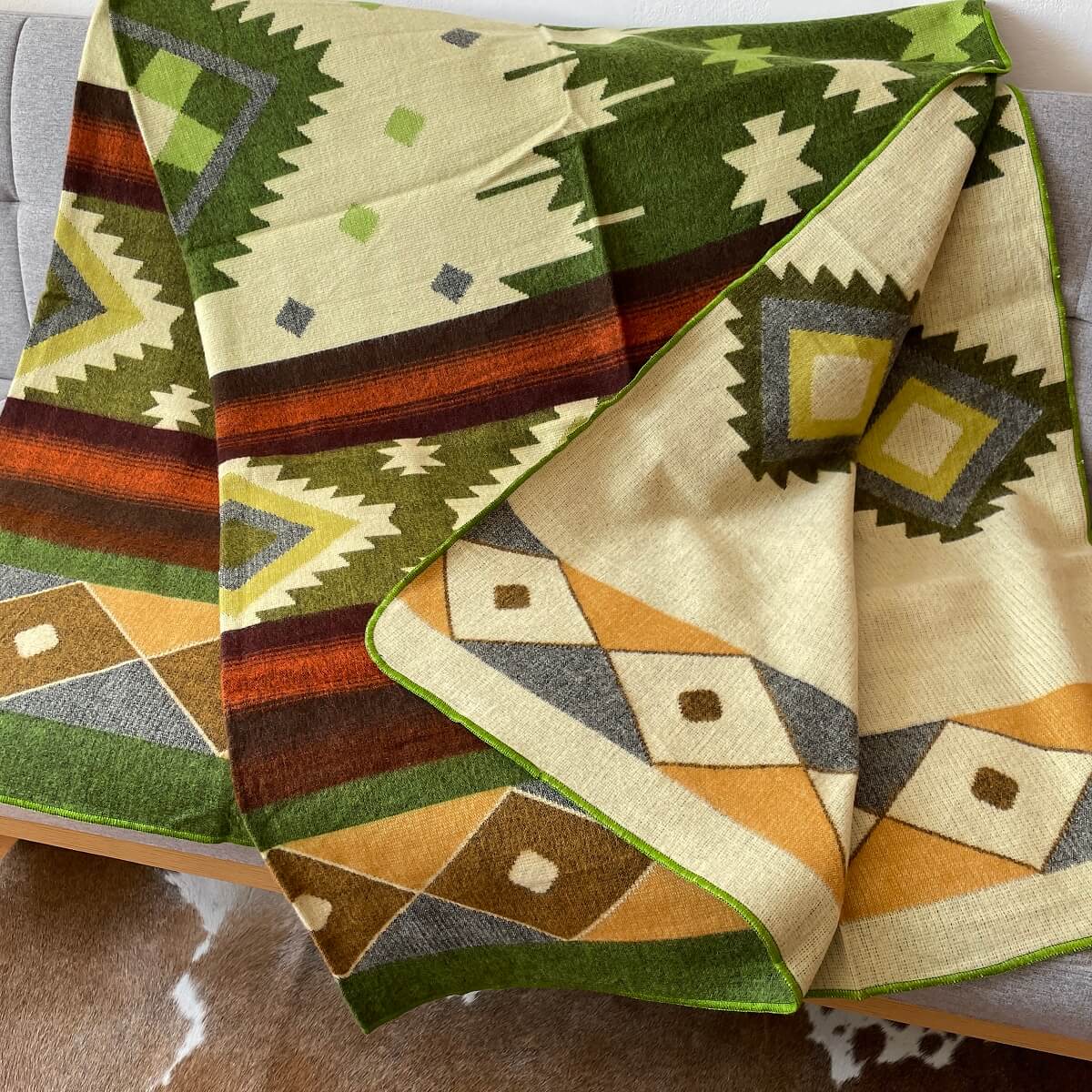 patura reversibila din lana alpaca quilotoa nuante de verde pe canapea desfacuta, mango+bloom