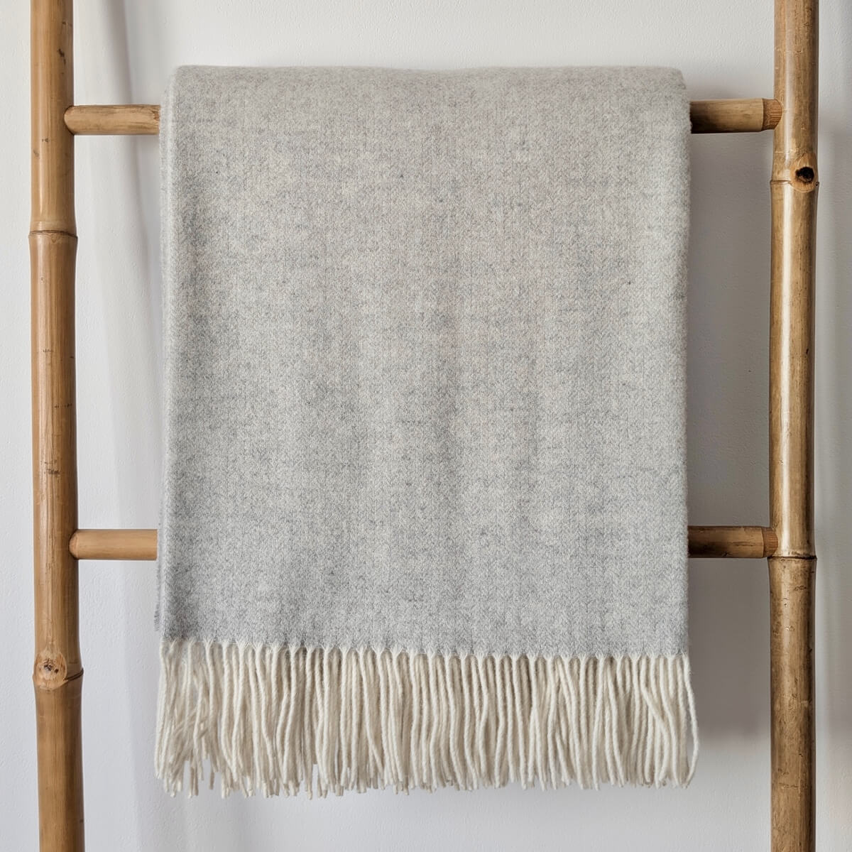 Patura Milano realizata din 90% lana merino si 10% casmir, functioneaza atat ca patura pentru canapea cat si ca cuvertura de pat, design modern gri, pe scara