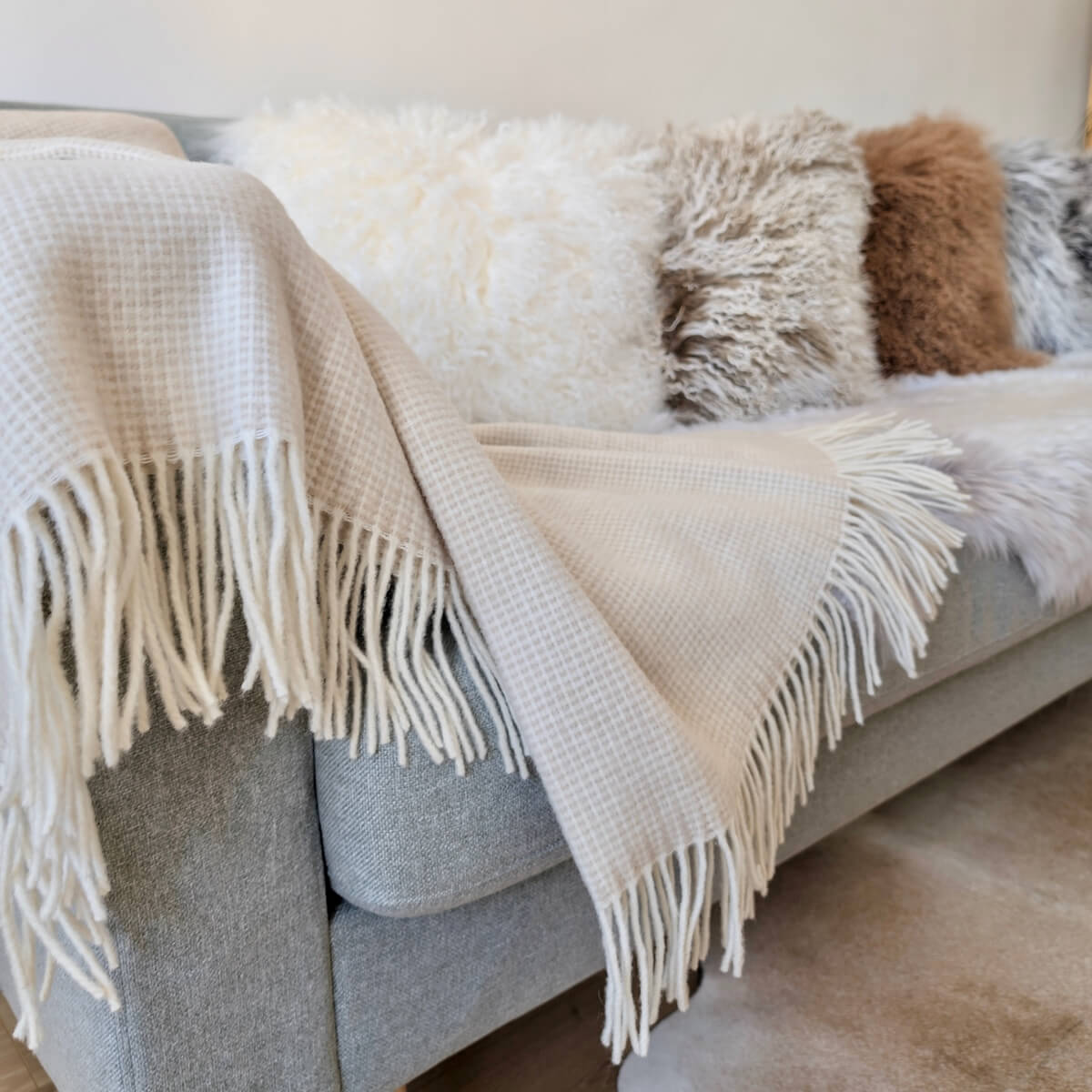 Patura 100% din lana merino Portofino, Bej, model simplu dar elegant si atemporal, pe canapea