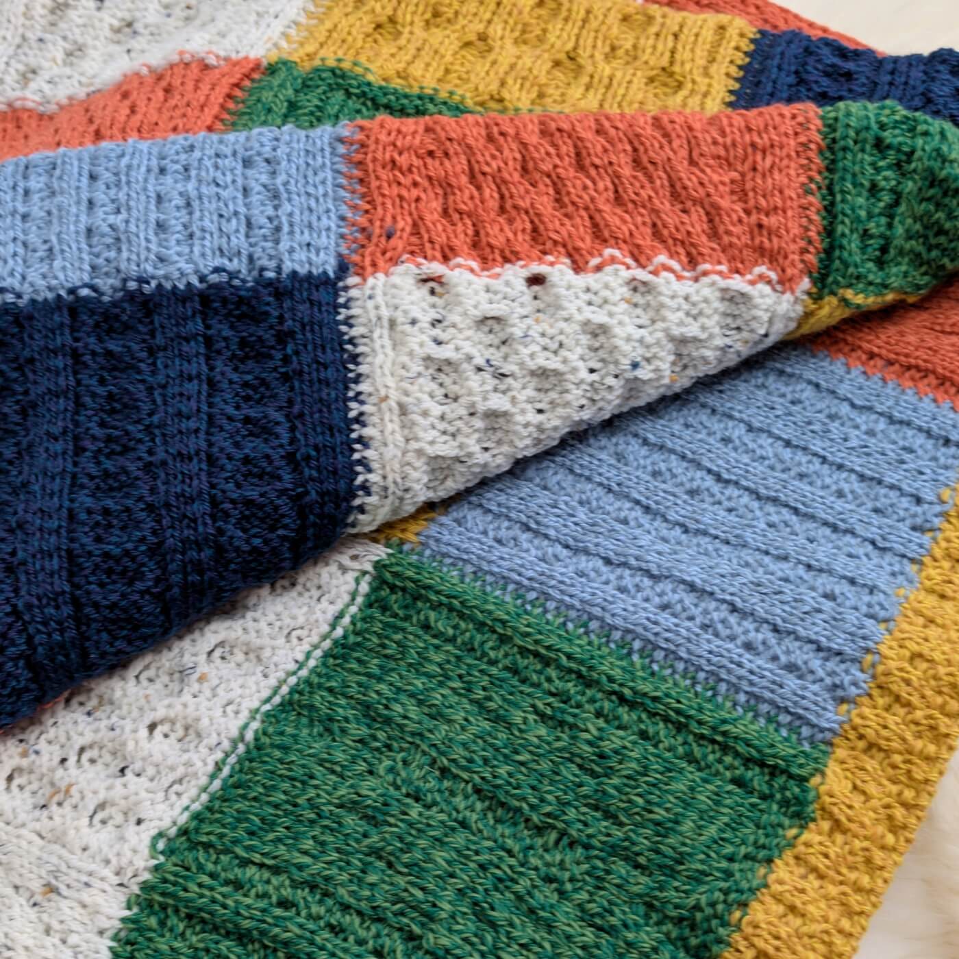 pătură tricotată lână merino supersoft Killala Aran, model carouri din pătrate, colorată