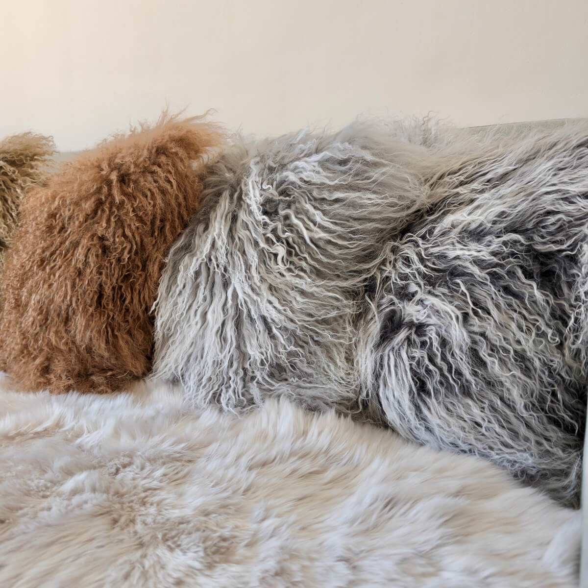 perne decorative din blana de oaie cu fir lung incretit, pe canapea, nuante de gri