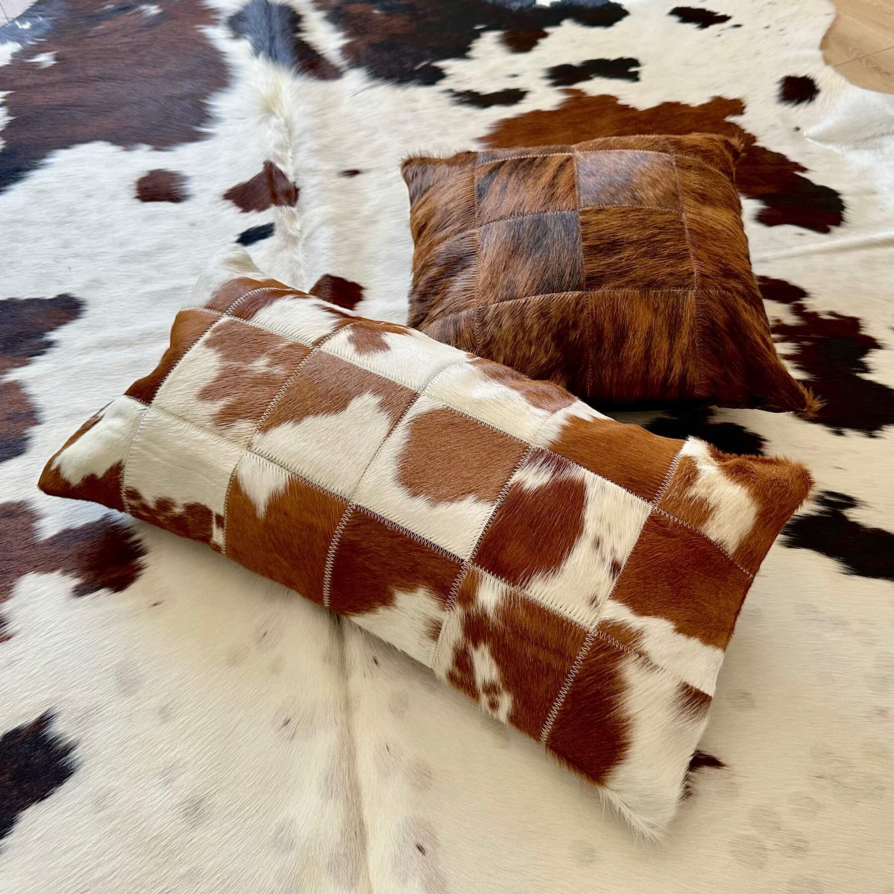 promotie - perna decorativa din piele la 99 lei impreuna cu un covor din piele de vaca - pe podea