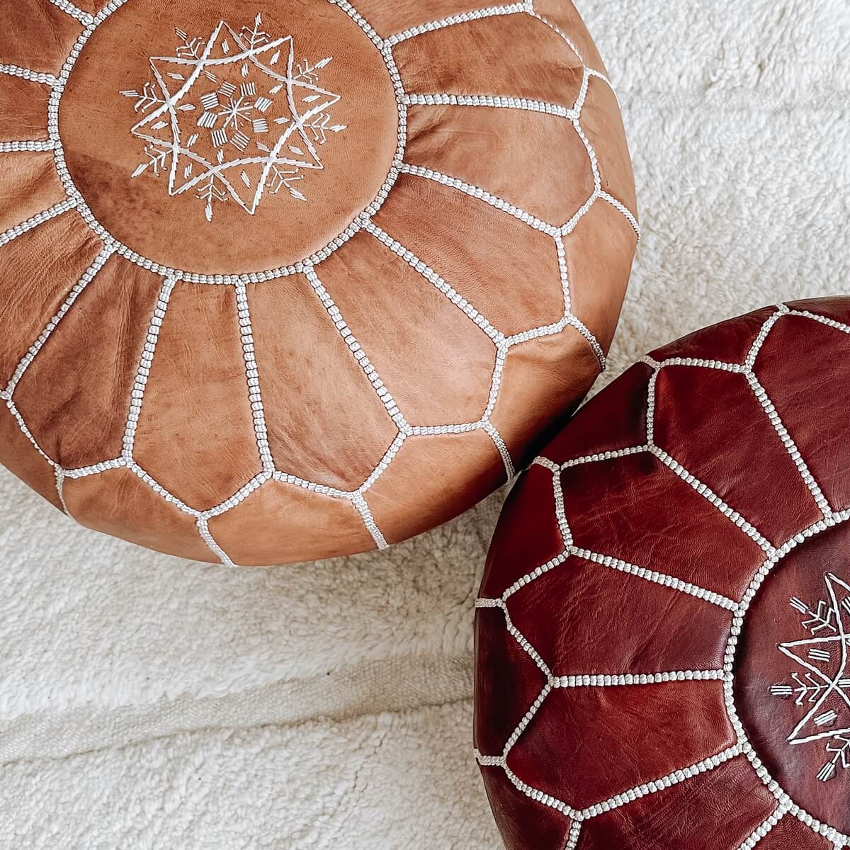 pouf marocan din piele naturala cusut manual de culoare maro deschis, langa al puf bordo