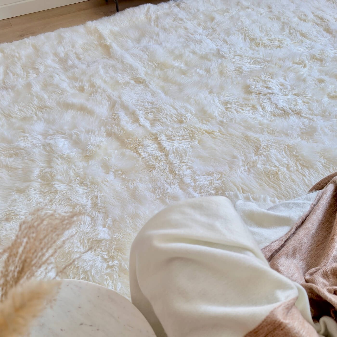 Covor dreptunghiular 300x200 din blană naturală de oaie australiană cu fir lung în nuanța de alb ivory. Somptuos și moale, pe podea în living