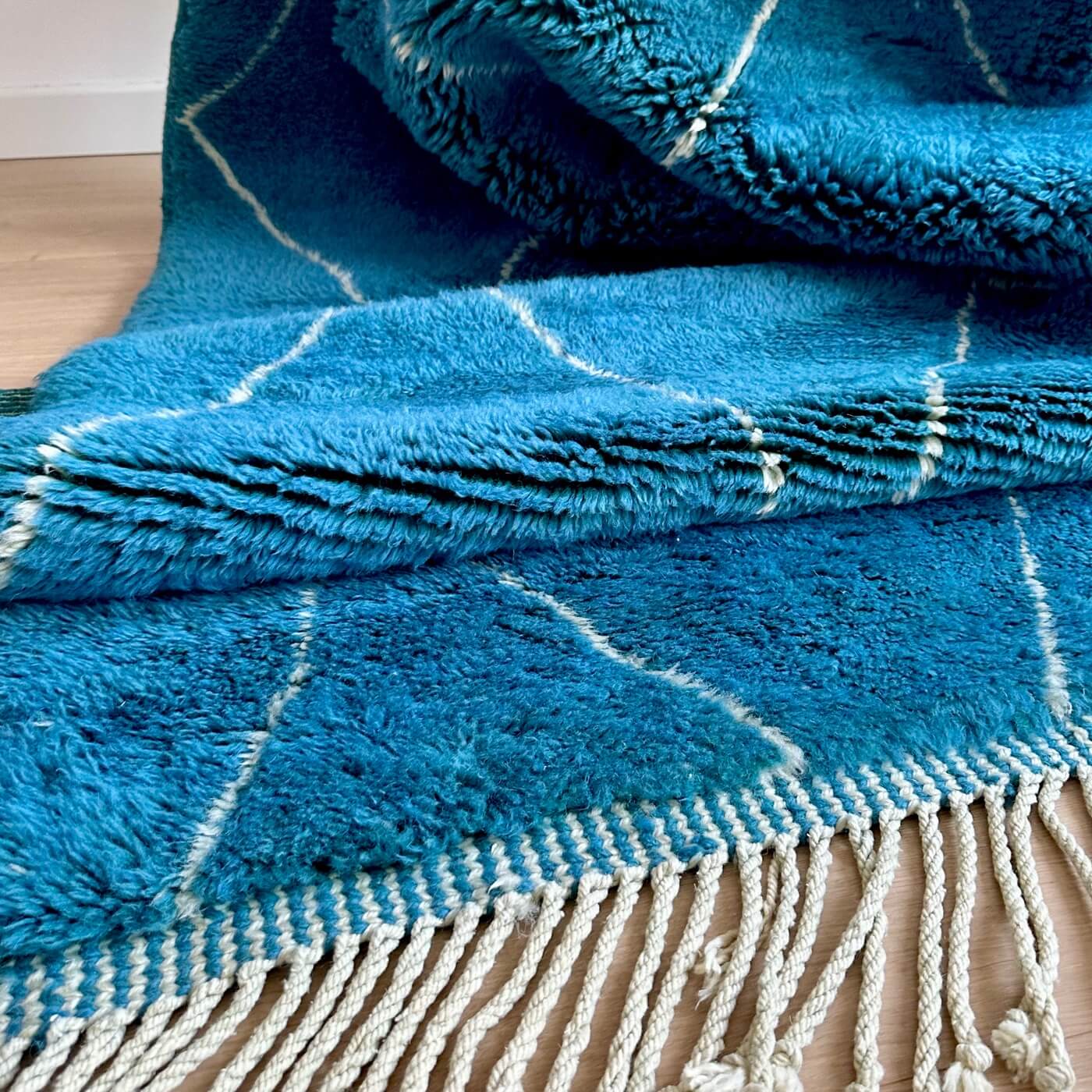 Covor gros și pufos din lână naturală realizat manual în Mrirt, Maroc. Perfect pentru living sau dormitor - dimensiune mare cu linii asimetrice albe pe un fundal albastru turcoaz - de aproape 3