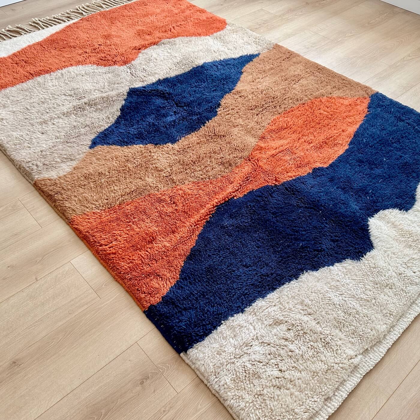 Covor modern gros și pufos din lână naturală realizat manual în Mrirt, Maroc. Perfect pentru living sau dormitor - dimensiune medie în culori de bej, maro, teracota si albastru - pe podea 2