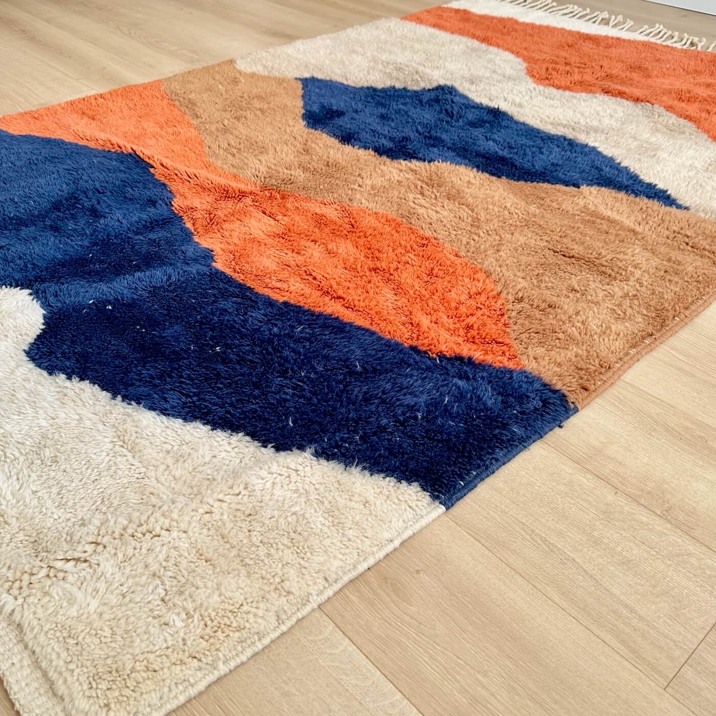 Covor modern gros și pufos din lână naturală realizat manual în Mrirt, Maroc. Perfect pentru living sau dormitor - dimensiune medie în culori de bej, maro, teracota si albastru - pe parchet 1