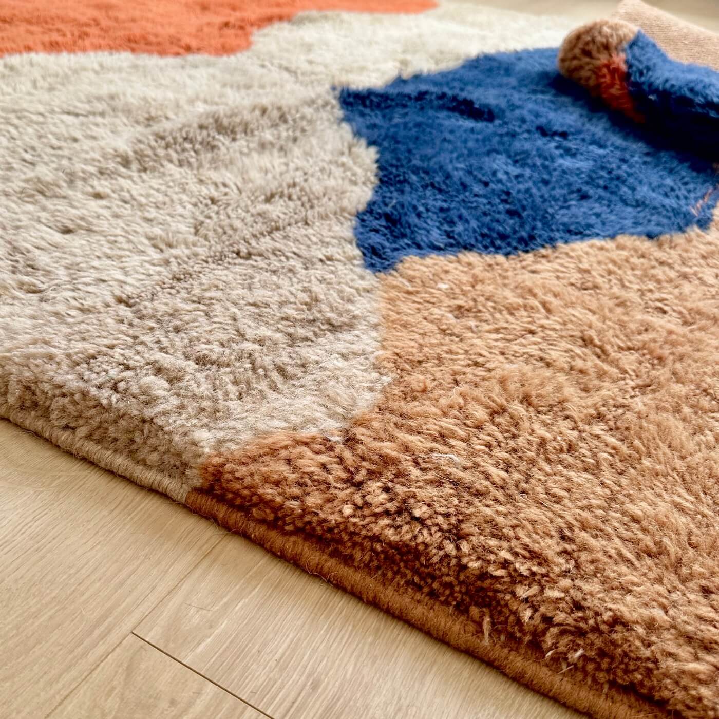 Covor modern gros și pufos din lână naturală realizat manual în Mrirt, Maroc. Perfect pentru living sau dormitor - dimensiune medie în culori de bej, maro, teracota si albastru - close up