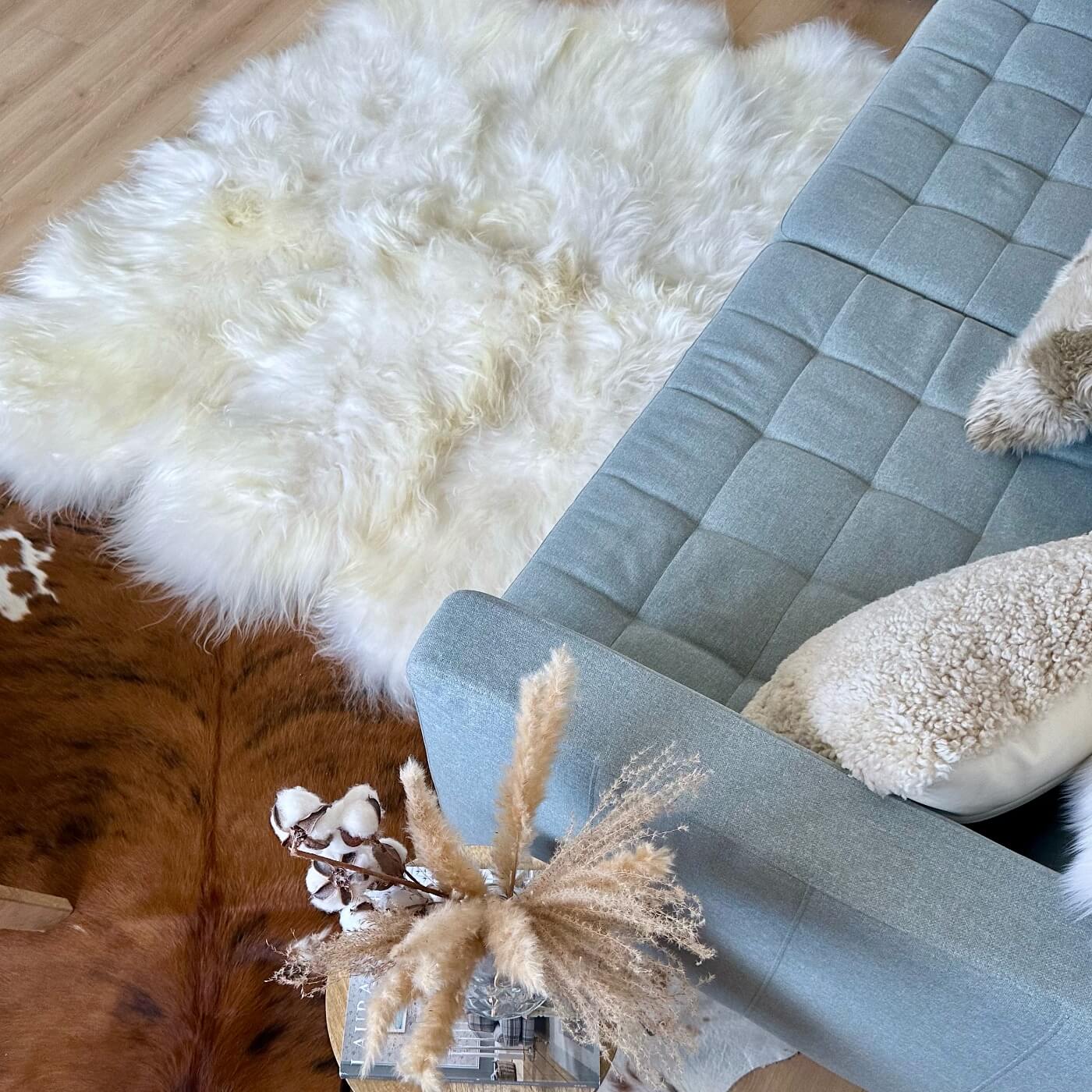 Covor sexto din blană naturală de oaie islandeză realizat din 6 piei întregi cusute împreună, în fața canapelei
