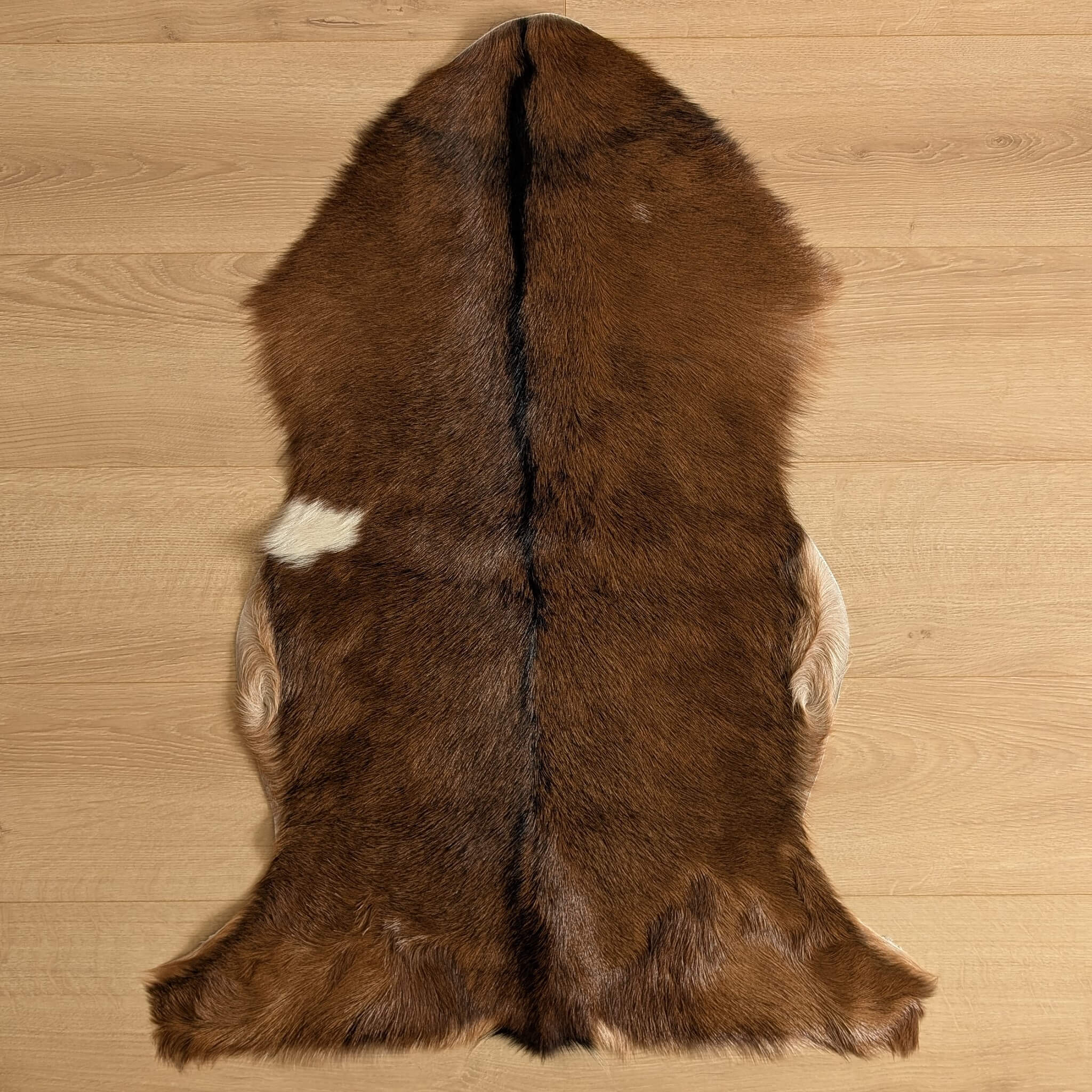 covor din piele naturala de capra maro inchis cu o pata alba