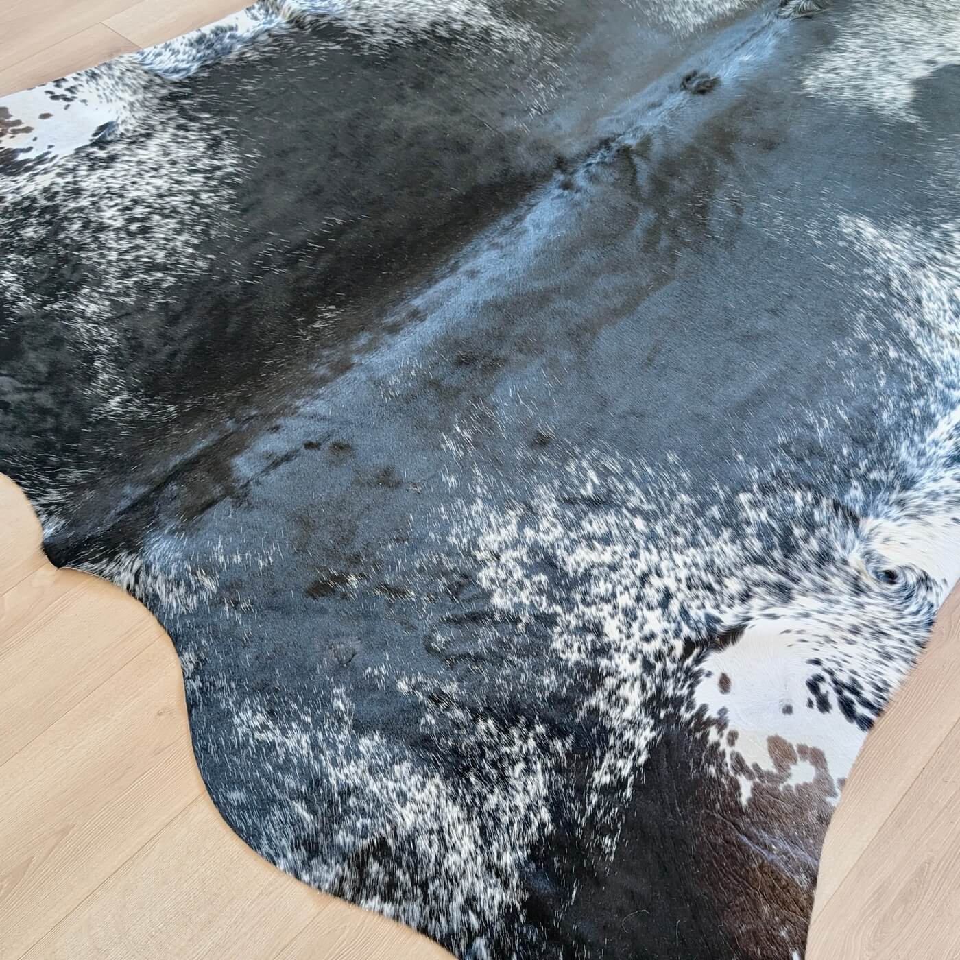 covor din piele de vaca pestrit cu fundal negru si detalii albe si gri - perfect pentru living, studio sau birou