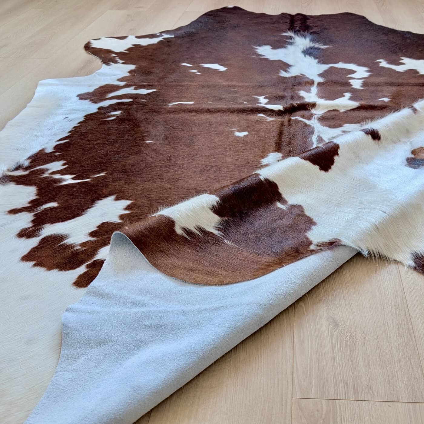 covor piele vaca 100% natural - fotografii reale - marime XL - maro cu pete albe - perfect pentru living, studio sau birou - de aproape
