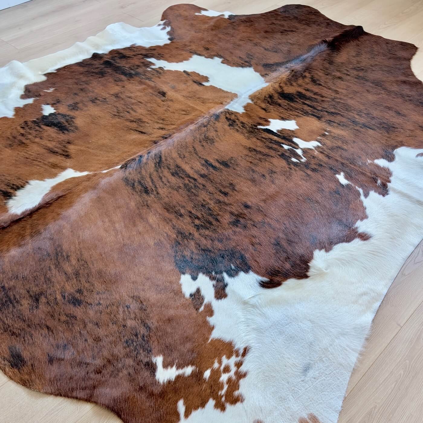 covor piele vaca cu model exotic - culoare maro cu pete albe - marime XL pentru living, studio sau birou - pe podea
