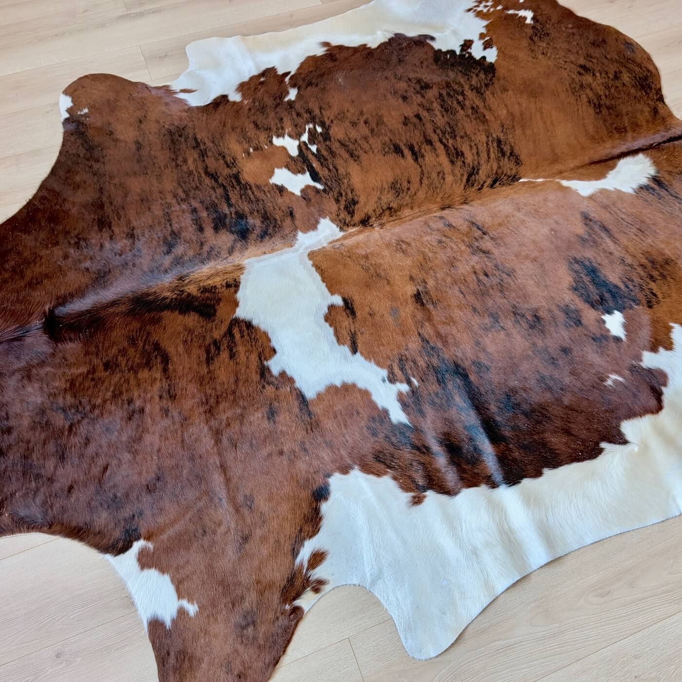 covor piele vaca cu model exotic - culoare maro cu pete albe - marime XL pentru living, studio sau birou - pe parchet