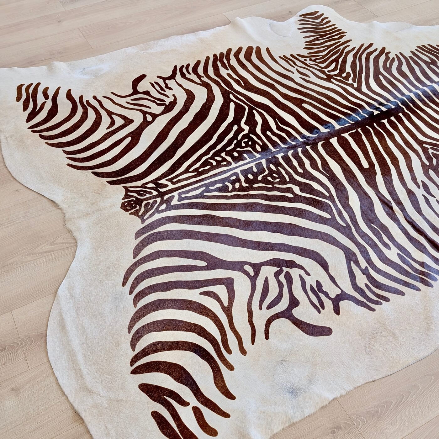 Covor din Piele de Vacă - Animal Print - Imprimeu Zebră (230x195 cm) pe un fundal de bej deschis cu dungi negre