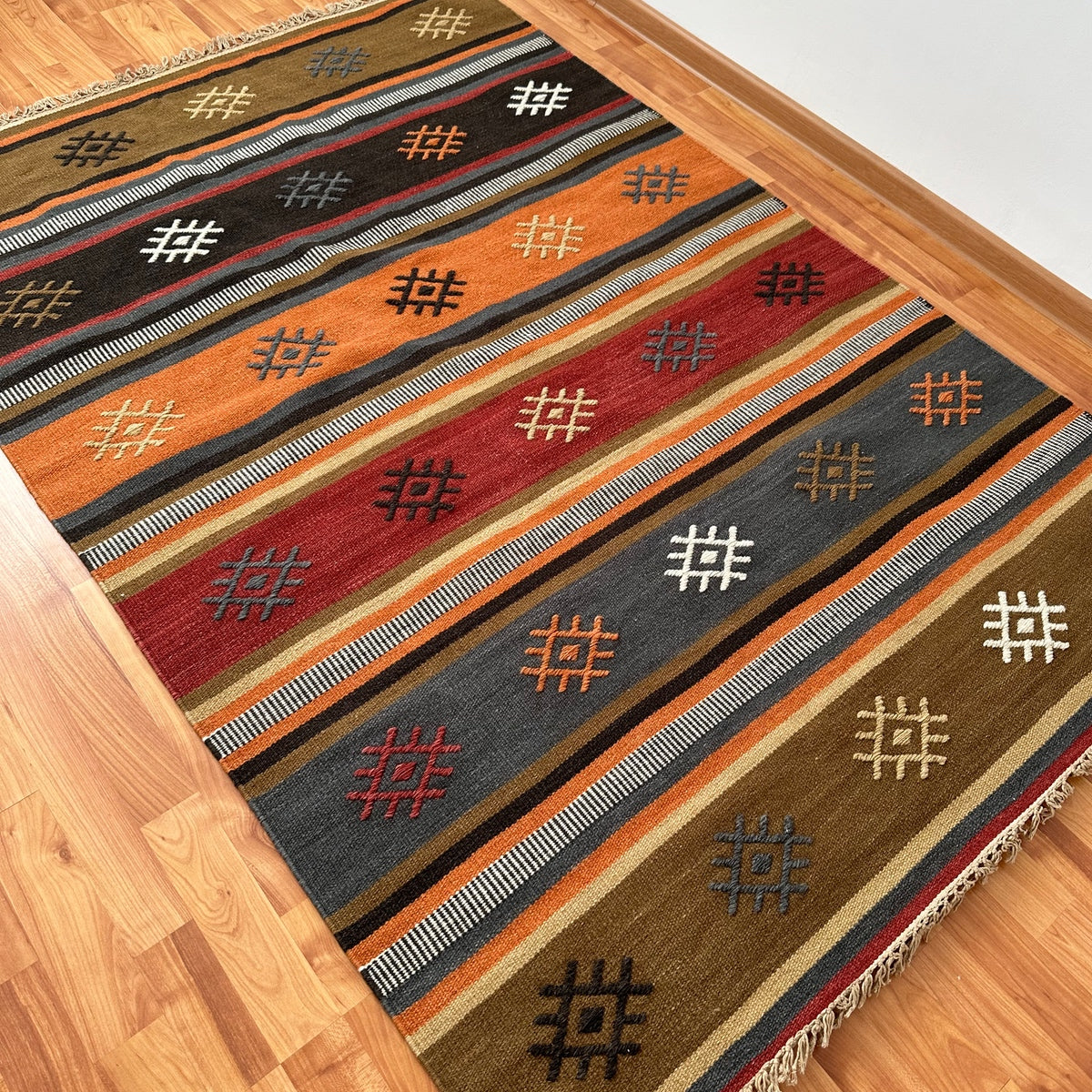 covor kilim Juma tesut traditional din lana si bumbac, culori si nuante pamantii calde cu modele, pe podea